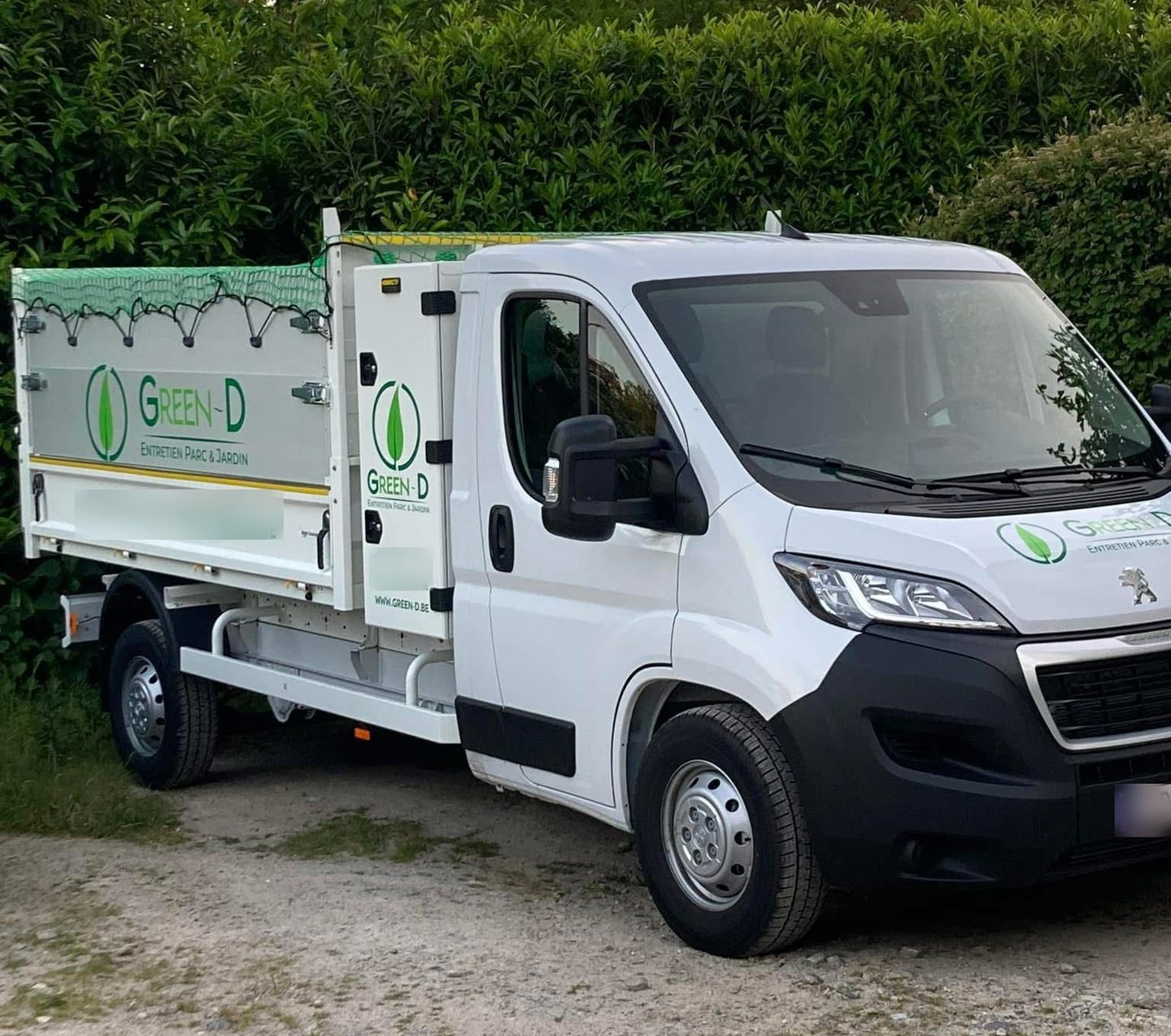 Green-D van in the brand colours, parked in front of a house